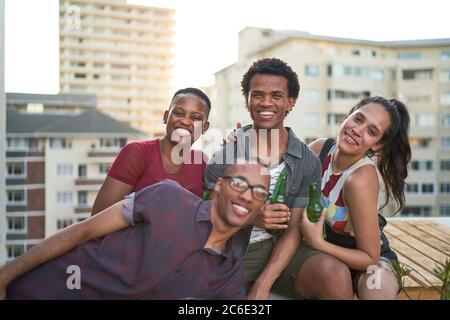 Portrait glückliche junge Freunde hängen auf sonnigen städtischen Dach Stockfoto