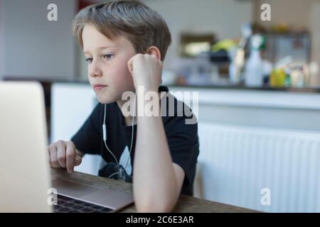 Fokussierter Junge mit Kopfhörern Heimschooling am Laptop Stockfoto