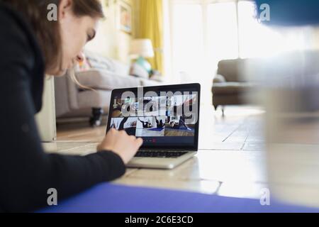 Teenager-Mädchen trainieren online auf Laptop-Bildschirm auf dem Boden Stockfoto
