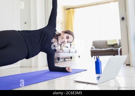 Teenager Mädchen Yoga online am Laptop zu Hause üben Stockfoto