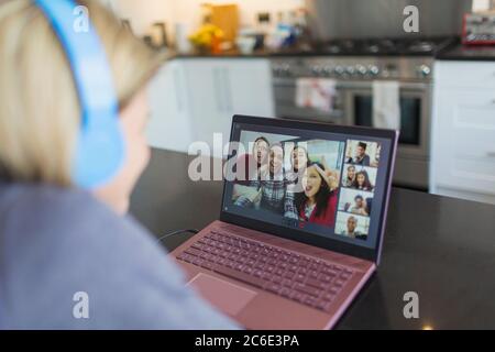 Frau mit Laptop Video chatten mit Freunden in der Küche Stockfoto