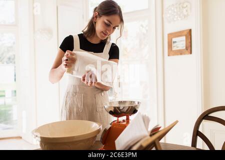 Frau, die Mehl zum Backen in der Küche misst Stockfoto