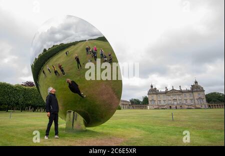 Der Künstler Anish Kapoor blickt vor der Eröffnung seiner größten britischen Ausstellung von Outdoor-Skulpturen in Houghton Hall, King's Lynn, in seine Skulptur 'Sky Mirror'. Stockfoto