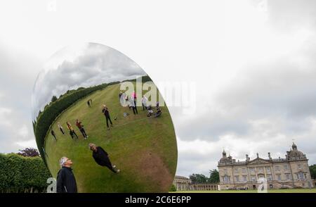 Der Künstler Anish Kapoor blickt vor der Eröffnung seiner größten britischen Ausstellung von Outdoor-Skulpturen in Houghton Hall, King's Lynn, in seine Skulptur 'Sky Mirror'. Stockfoto