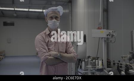 Arbeiter / Ingenieur tragen Entsorgung Gesichtsmaske zum Schutz von Staub Rauch und Corona-Virus während der Arbeit am Arbeitsplatz oder Fabrik.Kamera Drehen um einen Arbeitsplatz Stockfoto