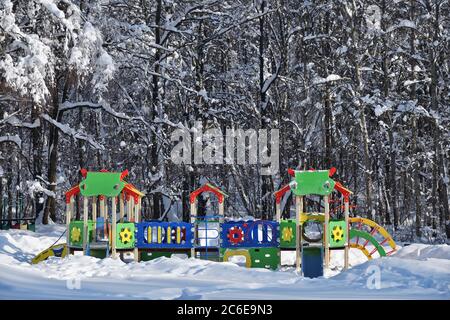 Öffentlicher Spielplatz in der Stadt Moskau. Hell bunt leer Kinderspielplatz im Winterhof eines Stadtpark Wald. Das Konzept der Stadt i Stockfoto