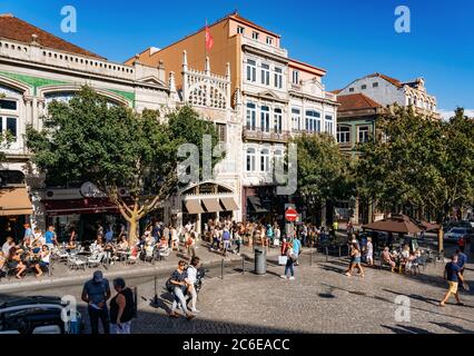 Porto, Portugal - 28. September 2018: Berühmte Bibliothek, Buchhandlung Livraria Lello und gemütliche Straße mit Menschen in Restaurants und Cafés an einem sonnigen Tag in Stockfoto