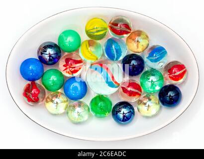 Bunte Murmeln in einer Schale vor weißem Hintergrund Stockfoto