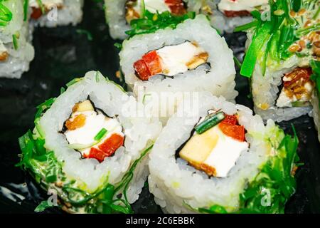 Brötchen mit Fisch, Käse und Grünalgen. Ein traditionelles japanisches Gericht. Nahaufnahme Stockfoto