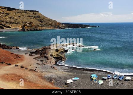 Lanzarote, Fischerboote am schwarzen Sandstrand im Golf von El Golfo, Atlantik in der Nähe des Lago de los Clicos auf den Kanarischen Inseln. Spanien Stockfoto