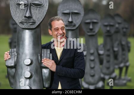 Künstler Zak Ove in der Mitte seiner 80 identischen Graphitfiguren im Yorkshire Sculpture Park in Wakefield, UK. Die zwei Meter hohen Skulpturen sind Teil Stockfoto