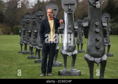 Künstler Zak Ove in der Mitte seiner 80 identischen Graphitfiguren im Yorkshire Sculpture Park in Wakefield, UK. Die zwei Meter hohen Skulpturen sind Teil Stockfoto