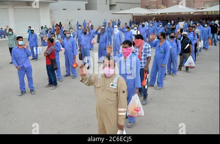 Kuwait-Stadt, Kuwait. Juli 2020. Die Arbeiter warten darauf, nach Aufhebung der Sperrungsbeschränkungen an ihren Arbeitsplatz im Gebiet von Mahboula in Ahmadi, Kuwait, 9. Juli 2020, verlegt zu werden. Die kuwaitische Regierung hob am Donnerstag die Sperre in den Gebieten Jleeb Al-Shuyoukh und Mahboula auf. Die Sperre wurde den beiden im Ausland dominierten und stark besiedelten Gebieten seit dem 6. April auferlegt. Quelle: Asad/Xinhua/Alamy Live News Stockfoto