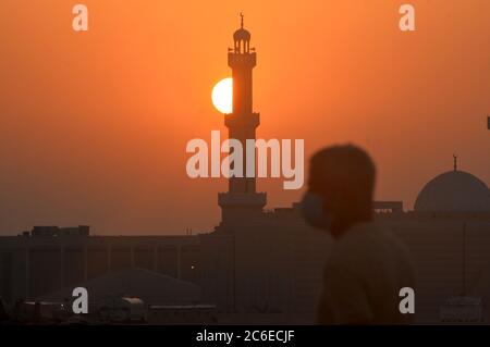 Kuwait-Stadt, Kuwait. Juli 2020. Ein Mann ist auf dem Weg zur Arbeit am Morgen in Mahboula Bereich nach der Aufhebung der Sperrbeschränkungen, in Ahmadi Governorate, Kuwait, 9. Juli 2020. Die kuwaitische Regierung hob am Donnerstag die Sperre in den Gebieten Jleeb Al-Shuyoukh und Mahboula auf. Die Sperre wurde den beiden im Ausland dominierten und stark besiedelten Gebieten seit dem 6. April auferlegt. Quelle: Asad/Xinhua/Alamy Live News Stockfoto