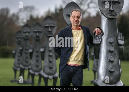 Künstler Zak Ove in der Mitte seiner 80 identischen Graphitfiguren im Yorkshire Sculpture Park in Wakefield, UK. Die zwei Meter hohen Skulpturen sind Teil Stockfoto