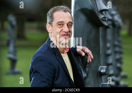 Künstler Zak Ove in der Mitte seiner 80 identischen Graphitfiguren im Yorkshire Sculpture Park in Wakefield, UK. Die zwei Meter hohen Skulpturen sind Teil Stockfoto