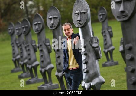 Künstler Zak Ove in der Mitte seiner 80 identischen Graphitfiguren im Yorkshire Sculpture Park in Wakefield, UK. Die zwei Meter hohen Skulpturen sind Teil Stockfoto