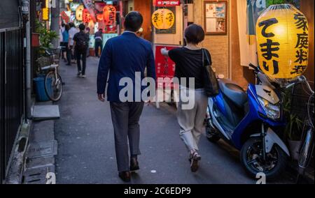 Menschen, die in der Hintergasse von Shimbashi spazieren, ein beliebtes Ziel für Büroangestellte in Tokio, Japan bei Nacht. Stockfoto