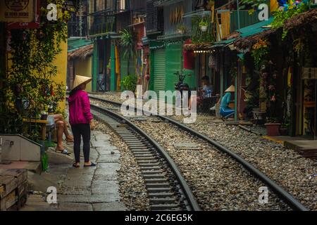 HANOI, VIETNAM, 4. JANUAR 2020: Einheimische Frau mit traditionellem Hut in der Zugreisse Stockfoto