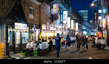 Menschenmenge in Yurakucho Hintergasse gefüllt mit kleinen Dinern, Pubs und Izakaya bei Nacht, Tokio, Japan. Stockfoto