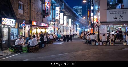 Menschenmenge in Yurakucho Hintergasse gefüllt mit kleinen Dinern, Pubs und Izakaya bei Nacht, Tokio, Japan. Stockfoto