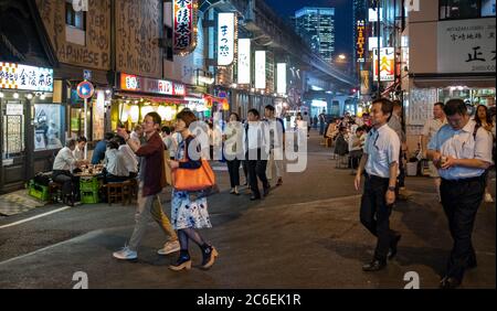 Menschenmenge in Yurakucho Hintergasse gefüllt mit kleinen Dinern, Pubs und Izakaya bei Nacht, Tokio, Japan. Stockfoto