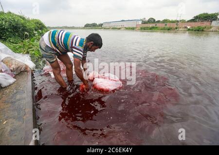 Tongi, Bangladesch. Juli 2020. Ein Mann aus Bangladesch wäscht Plastikmüll, der zum Transport von Chemikalien verwendet wurde, im Wasser des Turag-Flusses, bevor er ihn recycelt, in Tongi, nahe Dhaka, Bangladesch, 9. Juli 2020. Quelle: Suvra Kanti das/ZUMA Wire/Alamy Live News Stockfoto