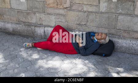 Ältere obdachlose Frau schläft auf dem Bürgersteig in Manhattan, NYC. Stockfoto