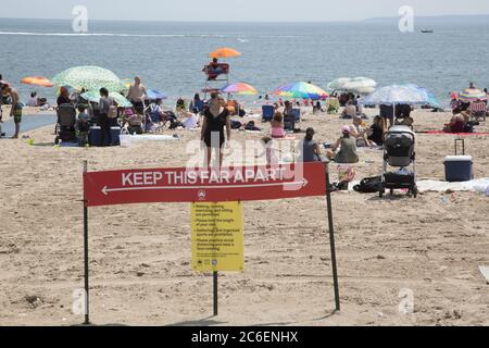 Mit dem Sommer hier beginnt der Strand von Coney Island trotz der Covid-19 Pandemie zu füllen. Die Menschen werfen ihre Masken in der Regel, während am Strand. Brooklyn, New York Stockfoto