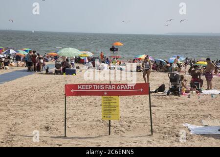 Mit dem Sommer hier beginnt der Strand von Coney Island trotz der Covid-19 Pandemie zu füllen. Die Menschen werfen ihre Masken in der Regel, während am Strand. Brooklyn, New York Stockfoto