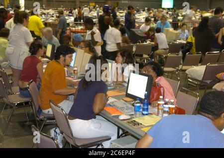 Austin, Texas USA, 3. September 2005: Flüchtlinge aus dem Hurrikan Katrina strömen weiterhin in texanische Unterkünfte, darunter das Austin Convention Center, das in den nächsten drei Tagen über 5.000 Menschen erwartet. Flüchtlinge nutzen Internetanschlüsse im Convention Center, um Nachrichten über Verwandte und andere wichtige Informationen zu erhalten. ©Bob Daemmrich Stockfoto