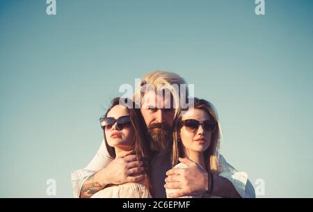 Portrait von glücklichen Mann zwischen zwei Mädchen auf Himmel Hintergrund im Sommerurlaub stehen. Stockfoto