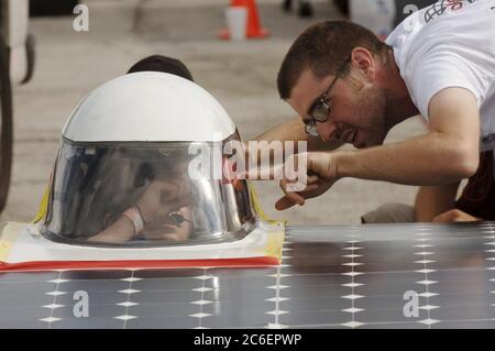 College Station, Texas, USA, 15. Juli 2005: College Student spricht mit dem Fahrer seines Teams bei Qualifikationsrennen für experimentelle Solarautos, die von College-Teams gebaut wurden, bevor das North American Solar Challenge 2.500 km Solar Car-Rennen von Austin, Texas, nach Calgary, Alberta, Kanada, begann. Die 10-tägige Veranstaltung umfasst 22 College- und Universitätsteams aus den USA und Kanada. ©Bob Daemmrich Stockfoto