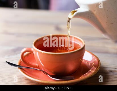 Teetasse mit heißer Teekanne. Glas Tasse heißen Kräutertee auf Holztisch im Restaurant Hintergrund. Stockfoto