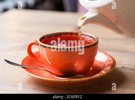 Teetasse mit heißer Teekanne. Glas Tasse heißen Kräutertee auf Holztisch im Restaurant Hintergrund. Stockfoto
