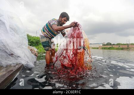 Tongi, Bangladesch. Juli 2020. Ein Mann aus Bangladesch wäscht Plastikmüll, der zum Transport von Chemikalien verwendet wurde, im Wasser des Turag-Flusses, bevor er ihn recycelt, in Tongi, nahe Dhaka, Bangladesch. Quelle: Suvra Kanti das/ZUMA Wire/Alamy Live News Stockfoto