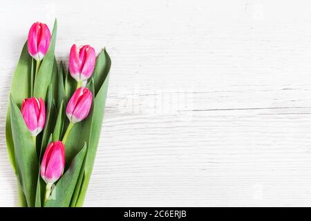 Schöne rosa Tulpen auf Holzhintergrund. Grußkarte mit Tulpen für Muttertag oder Ostern. Federkonzept. Stockfoto