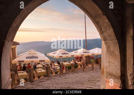 Essen im Freien im Restaurant mit Blick auf die Berge bei Sonnenuntergang, Motovun, Istrien, Kroatien Stockfoto