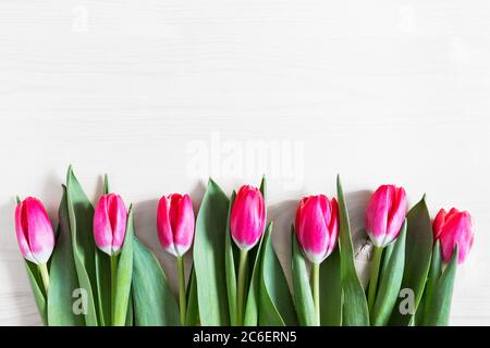 Schöne rosa Tulpen auf Holzhintergrund. Grußkarte mit Tulpen für Muttertag oder Ostern. Federkonzept. Stockfoto