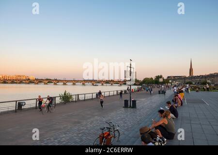 Promenade entlang des Flusses Garrone mit Spaziergängern und Radfahrern bei Sonnenuntergang, Bordeaux City, Frankreich Stockfoto