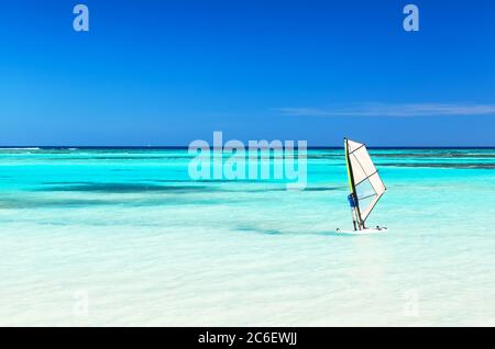 Windsurfer im Meer mit einem blauen Himmel Hintergrund. Windsurfen im Hintergrund der Ozeanlandschaft und klaren blauen Himmel. Stockfoto