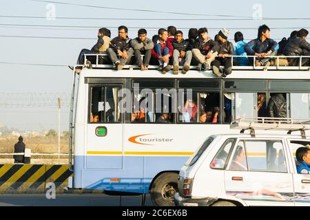 Kathmandu, Nepal - 22 Nov 2015: Pendler packen in und auf die seltenen Busse, die während der Benzinkrise 2015 noch immer die Vororte der Stadt bedienen, in Kat Stockfoto