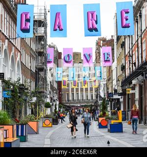 London, Großbritannien. Juli 2020. Das Kunstwerk des preisgekrönten britischen Designers Alex Fowke ist über der South Molton Street in Mayfair ausgesetzt und zeigt den Text HOFFNUNG, LIEBE, FÜRSORGE, ZEIT, die Bemühungen des NHS und der Schlüsselarbeiter während der laufenden Coronavirus-Pandemie und auch zum 72. Geburtstag des NHS zu würdigen. Kredit: Stephen Chung / Alamy Live Nachrichten Stockfoto
