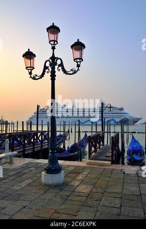 VENEDIG - SEP 27, 2014: Blick auf die Lagune von Venedig bei Sonnenaufgang, Kreuzfahrtschiff im Hintergrund. Touristen aus aller Welt genießen die historische Stadt Venezia Stockfoto