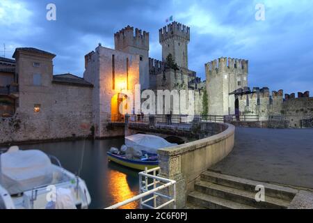 Nachtszene von Scaliger Castle, einer alten Festung, die den Eingang in Sirmione am Gardasee bewacht Stockfoto