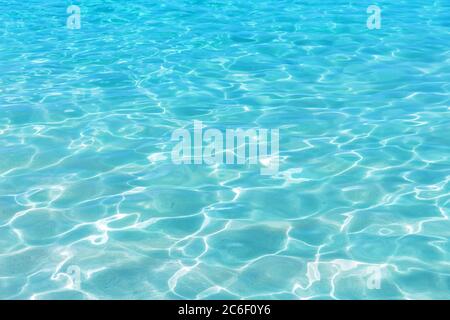 Leuchtendes blaues Wasser Welligkeit Hintergrund. Wasseroberfläche im Schwimmbad. Stockfoto