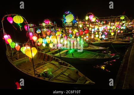 Asiatisches Boot mit farbigen chinesischen Laternen, die nachts im Wasser sein Licht reflektieren Stockfoto