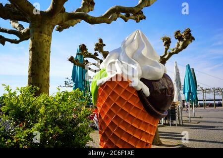 Sommer-Hintergrundbild mit selektivem Fokus auf einem dekorativen Eiskegel vor einem Café an der Rheinpromenade in Düsseldorf. Stockfoto