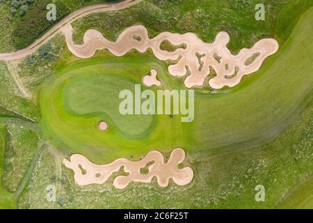 North Berwick, Schottland, Großbritannien. Juli 2020. Luftaufnahme der Golfer spielen Annäherung Schüsse auf Grün zwischen aufwendigen Bunkern auf Fidra Golfplatz Teil des Archerfield Links Entwicklung bei North Berwick in East Lothian. Iain Masterton/Alamy Live News Stockfoto