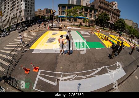 Lokale Künstler malen am Samstag, 4. Juli 2020, ein massives Wandgemälde „Black Lives Matter“ auf dem Adam Clayton Powell Blvd in Harlem in New York. (© Richard B. Levine) Stockfoto